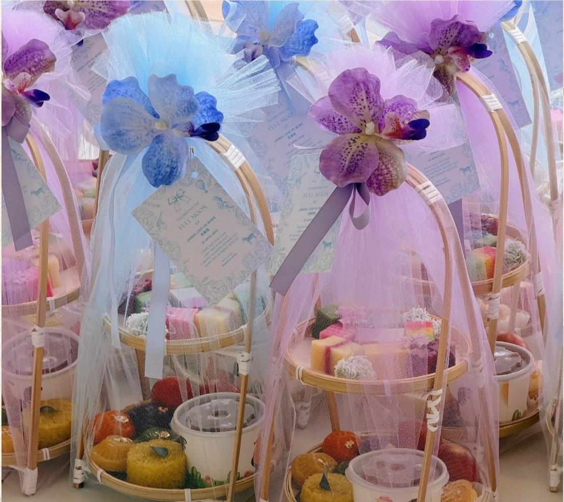 Luna's Bamboo Gift Set arranged in bamboo packaging with organza, holding four colour angku kuih, bite size Nyonya kuih, tarts, curry chicken and nasi pulut kunyit.