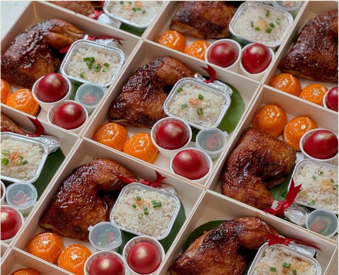 Luna's Roasted Chicken Gift Set featuring an XXL roasted chicken leg, fragrant scallion oil rice, angku kuih, pickled cucumber and traditional red eggs in bento packaging.